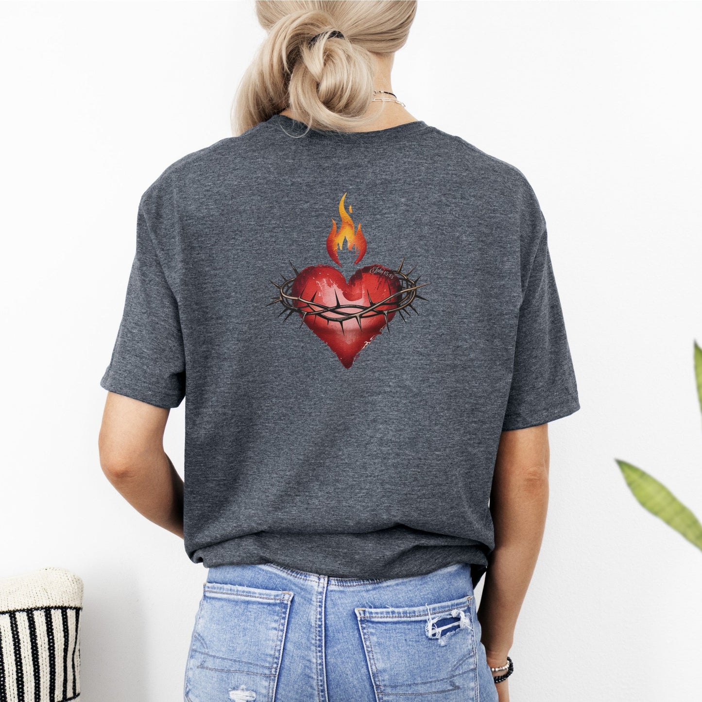 Person wearing a gray t-shirt with a heart design on the back, standing against a white background.